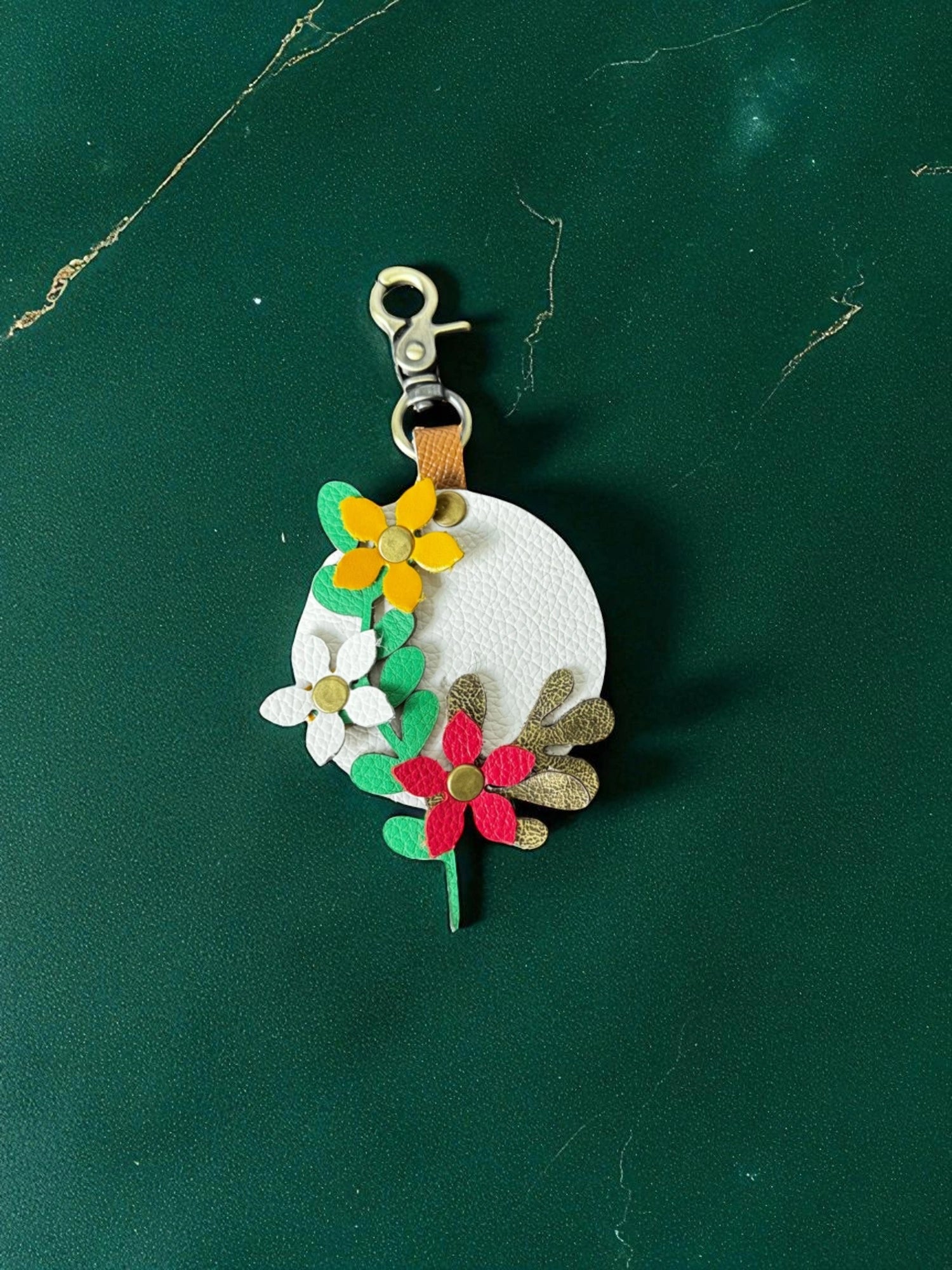 Floral keychain with colorful flowers on a green background