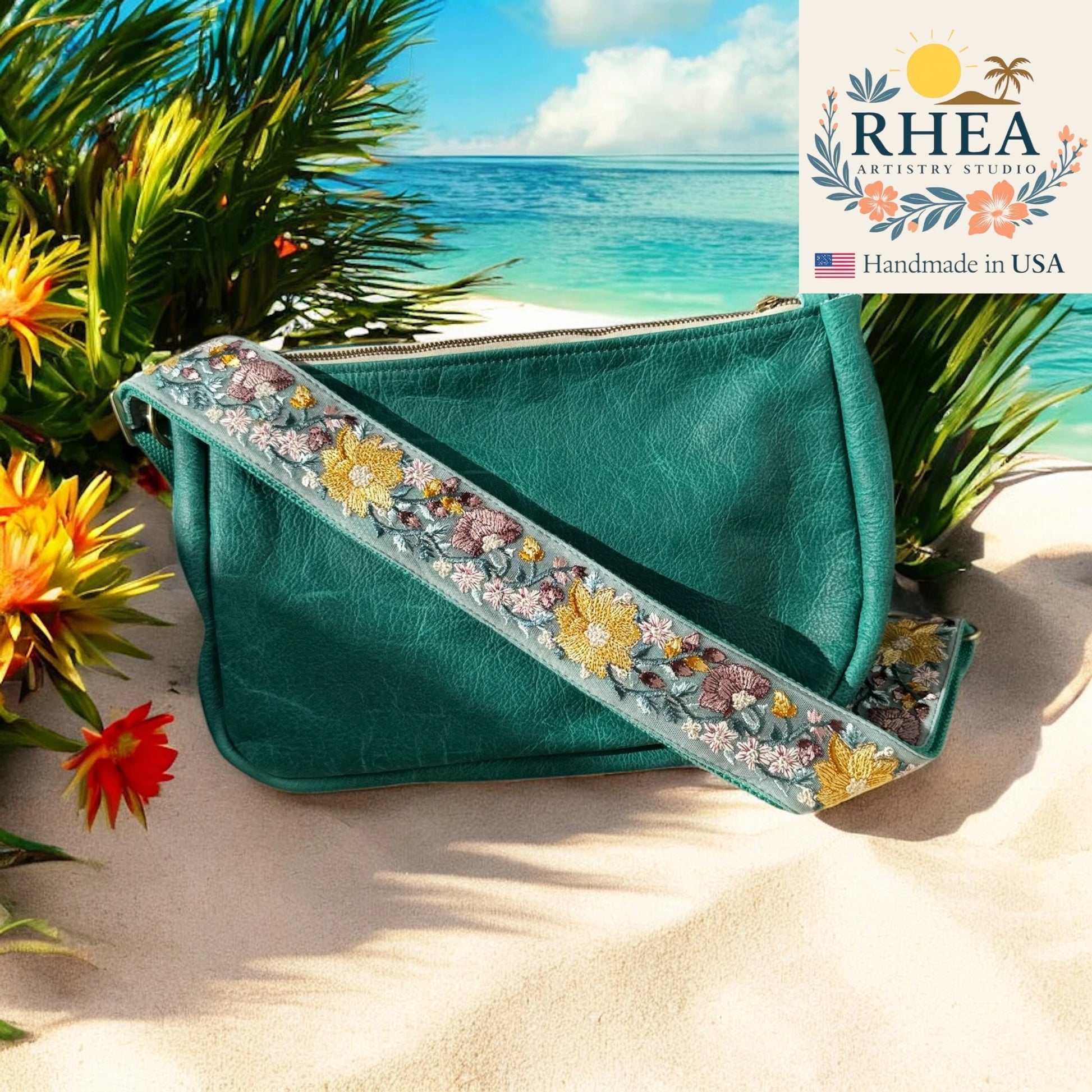 Teal handbag with floral purse strap on a beach with palm trees and flowers.