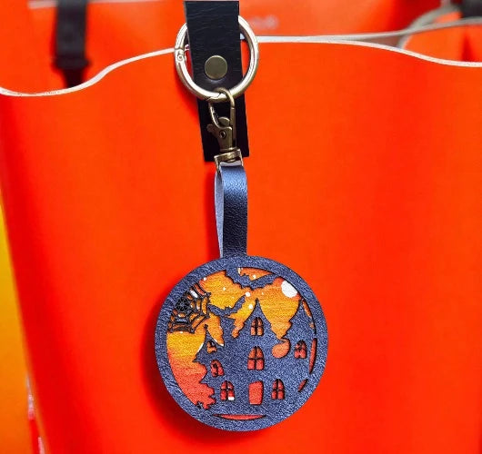 Decorative keychain with house design on a red background