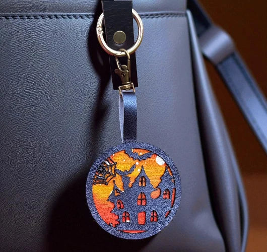 Decorative keychain with a house design on a blue bag