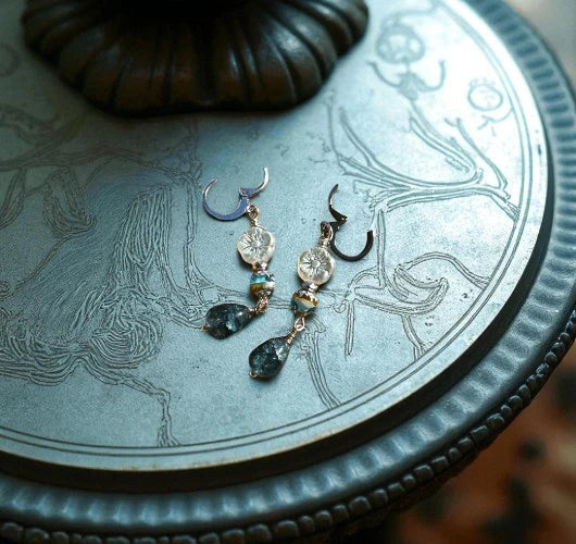 Pair of earrings on a decorative metal surface