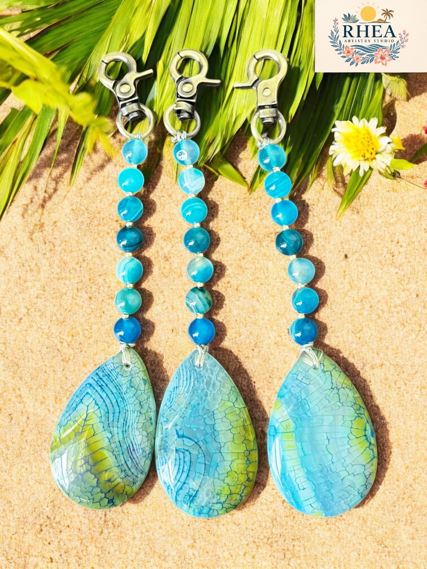 Blue beaded earrings with teardrop-shaped stones on a natural background