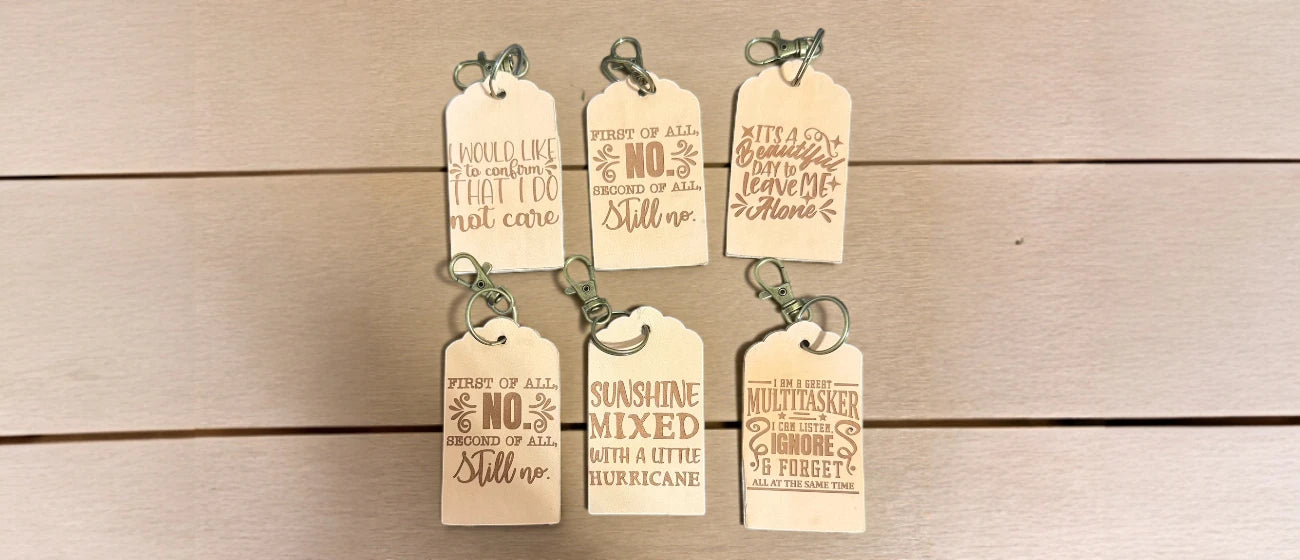 Set of leather tags with engraved text on a wooden surface