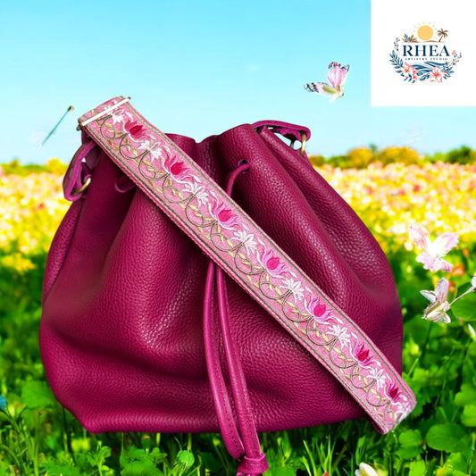 in the garden - A stunning pink embroidered strap with lotus flower motifs, designed in vibrant pinks and ivory, with leaf vines flowing along a rose-toned cotton webbing.