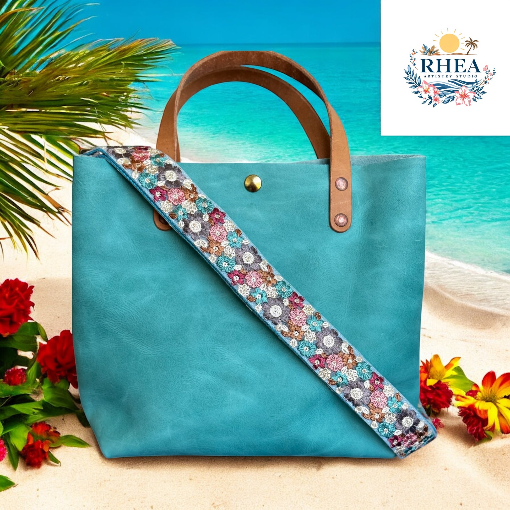 This Meadow Mosaic strap features a vibrant floral pattern on an aqua-blue base, accented with maroon, lavender, golden tan, and soft teal blooms. The combination of warm and cool tones creates a balanced, eye-catching design that adds a touch of artisanal charm to any bag. Perfect for spring and summer styling, this strap brings a fresh, meadow-inspired palette to your accessories at the beach
