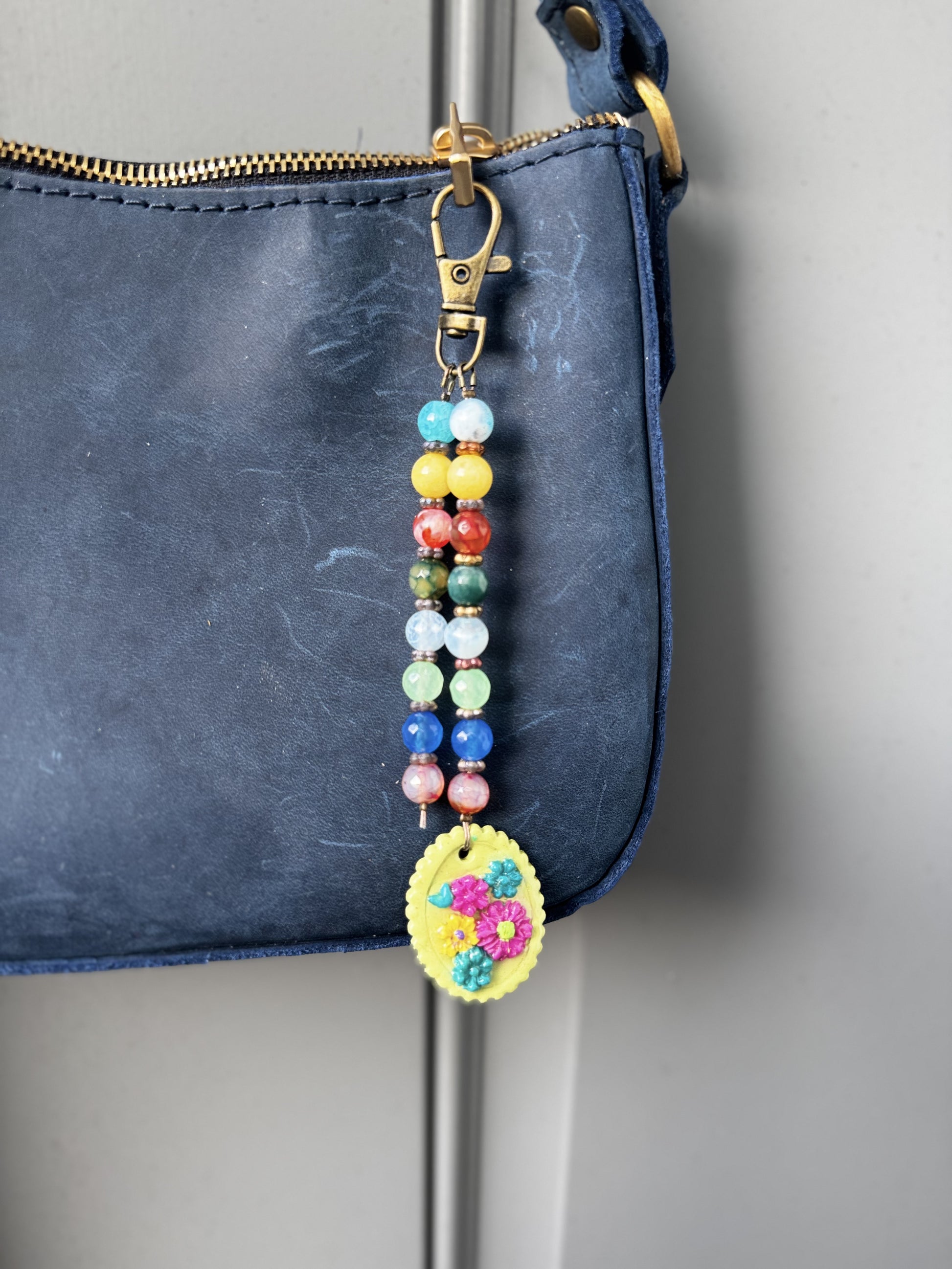 multi colored beaded on 2 strands with a handmade colorful pendant with lobster clasp