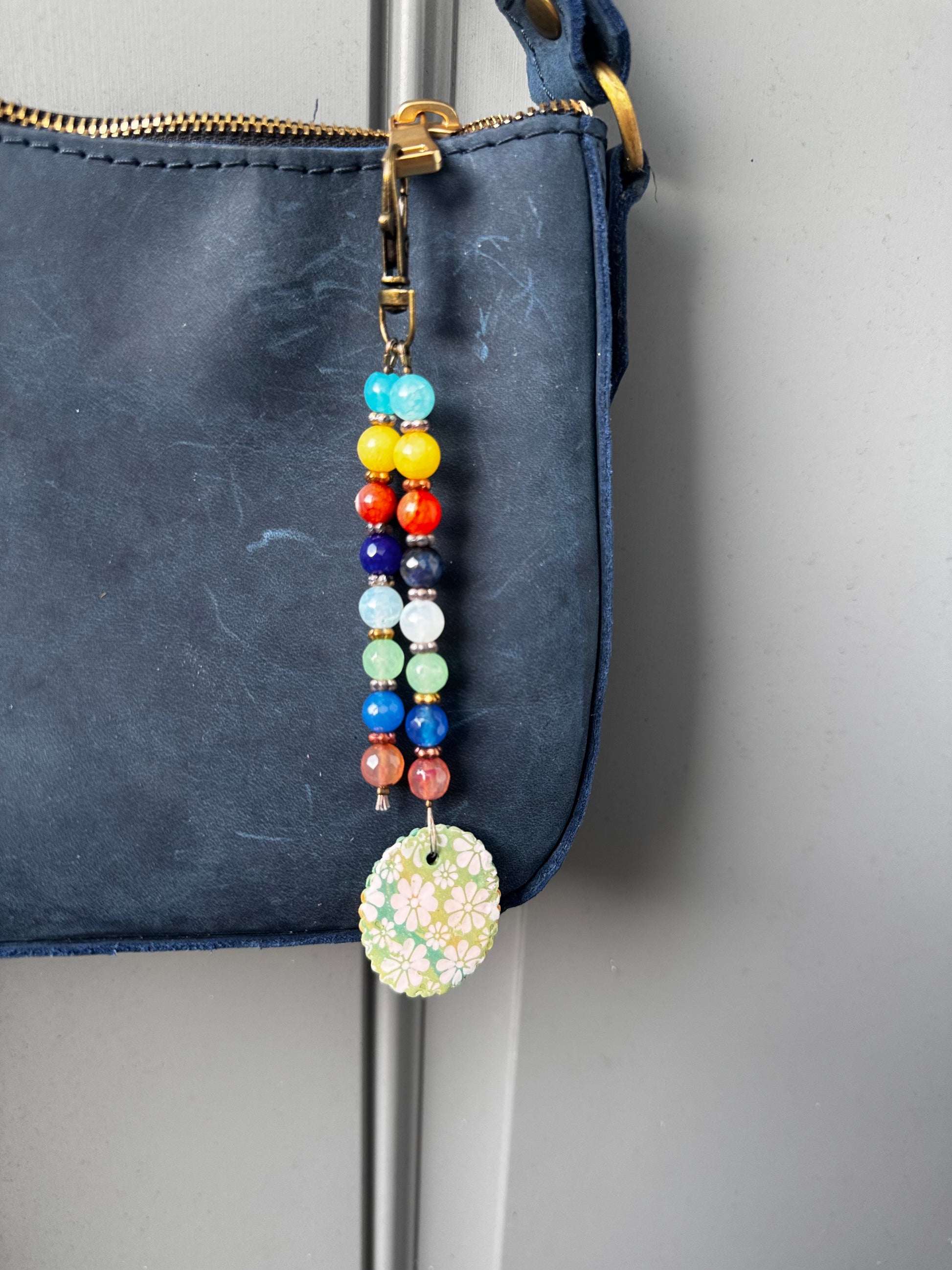 multi colored beaded on 2 strands with a handmade colorful pendant with lobster clasp