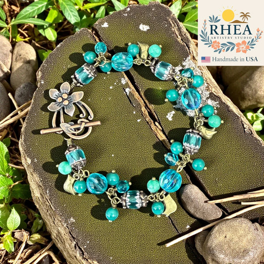 Handcrafted Ocean Bloom Bracelet featuring Czech glass beads, turquoise gemstones, and antique brass leaf accents in refreshing ocean-inspired tones.