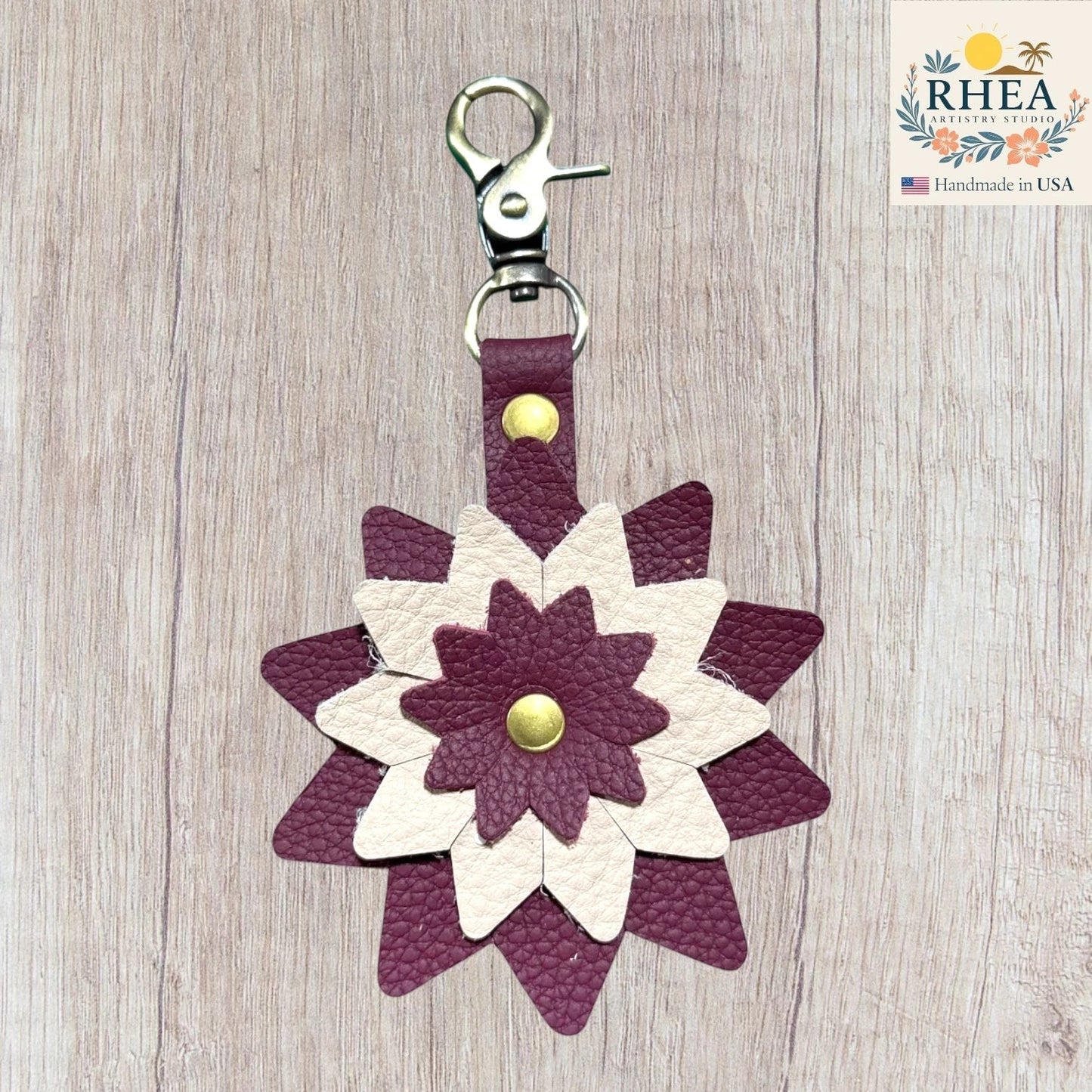 Floral-patterned keychain with purple and white design on a wooden surface, Handcrafted leather floral charm designed for purses and totes
