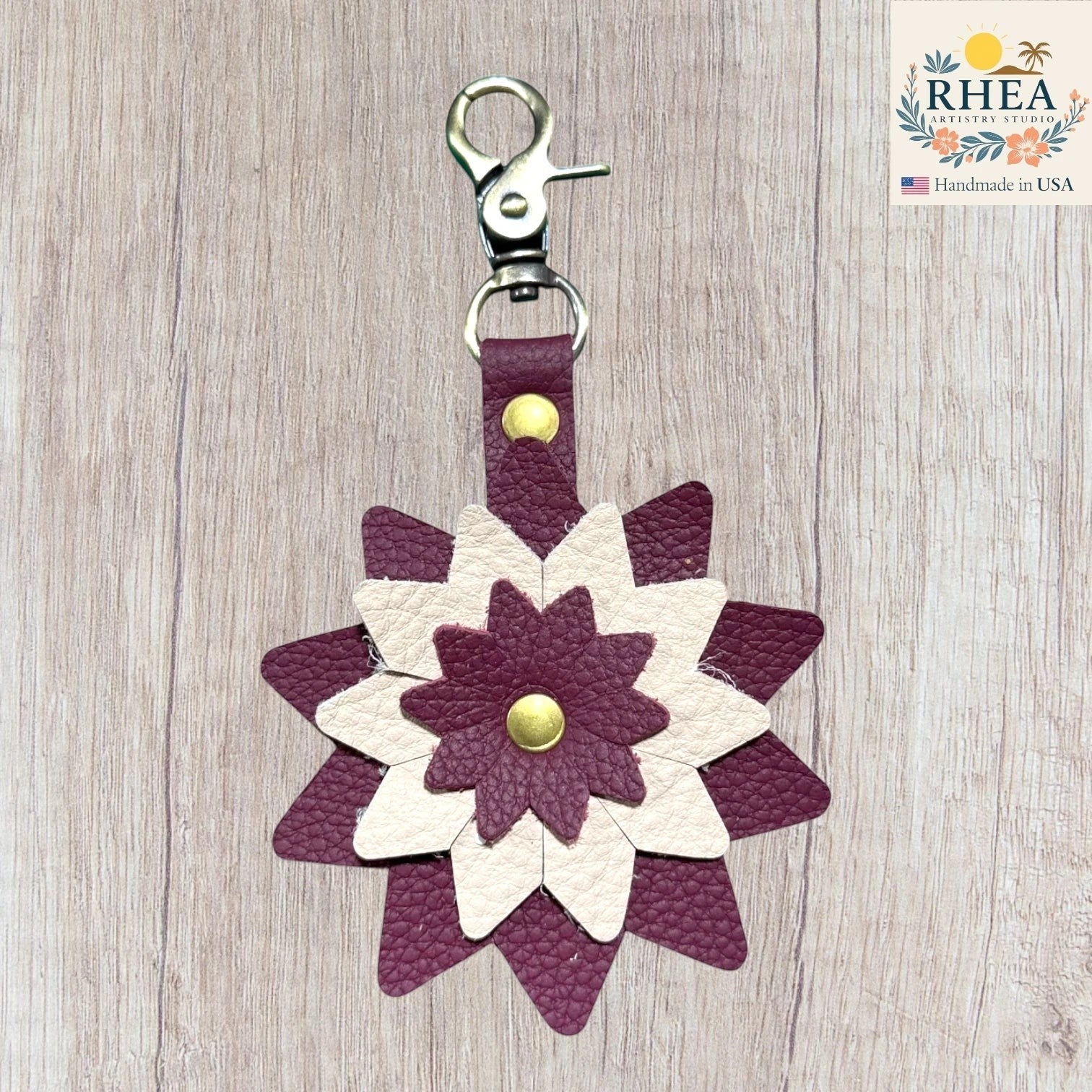 Floral-patterned keychain with purple and white design on a wooden surface, Handcrafted leather floral charm designed for purses and totes