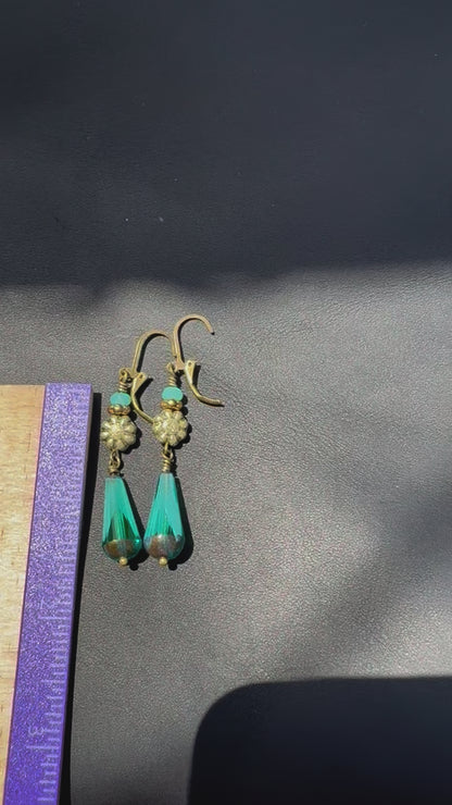 Boho-style long turquoise dangle earrings featuring gold details and faceted glass teardrops.