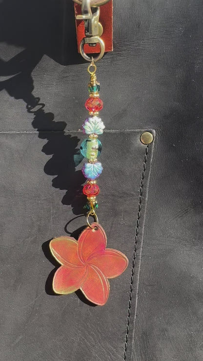 Flower-shaped keychain with beads on a black bag