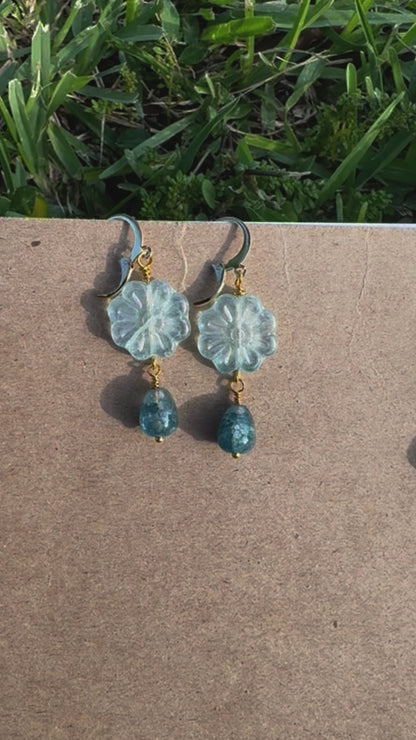 Floral earrings with blue beads on an old book
