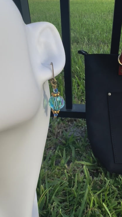 Gold and blue beaded earrings on a model