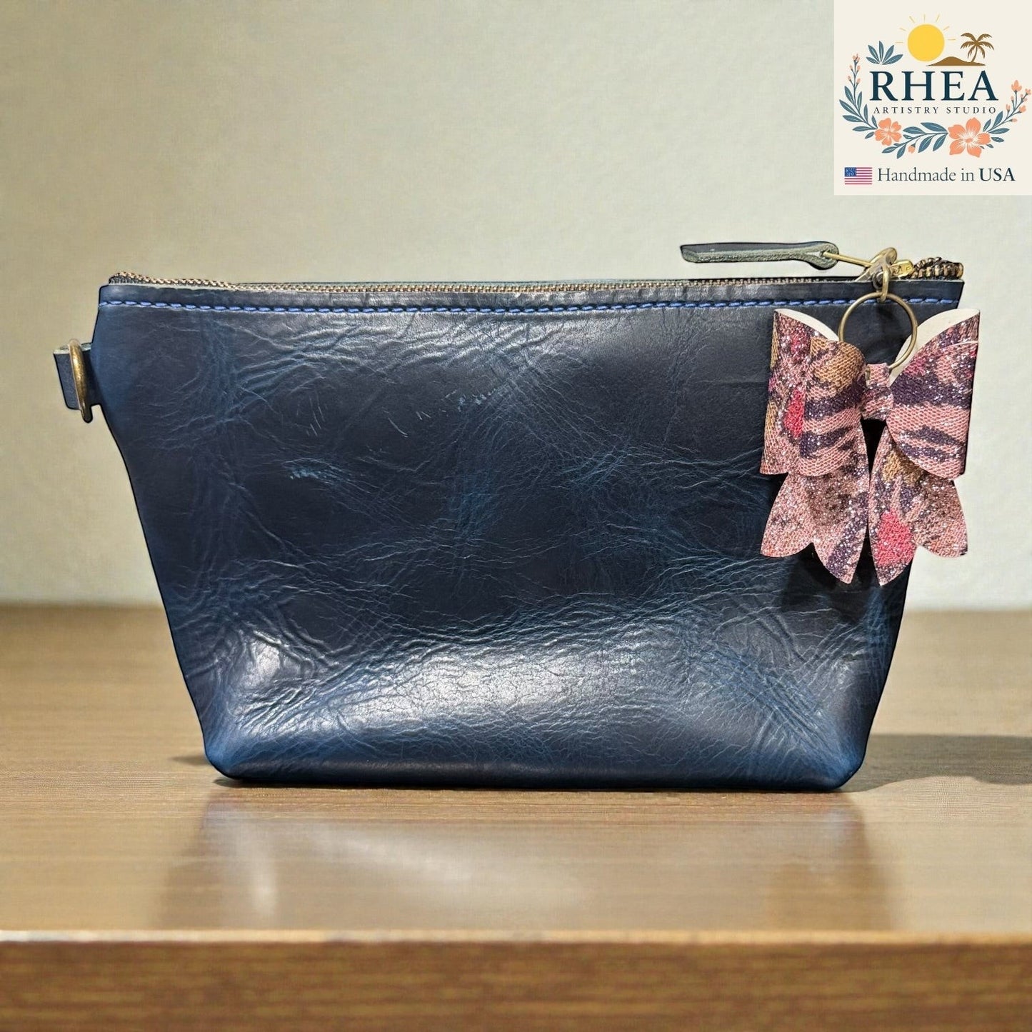Rhea Artistry Studio handmade animal print bow bag charm with brass hardware.