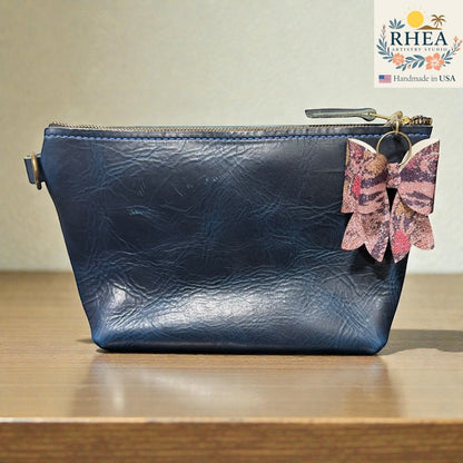 Rhea Artistry Studio handmade animal print bow bag charm with brass hardware.