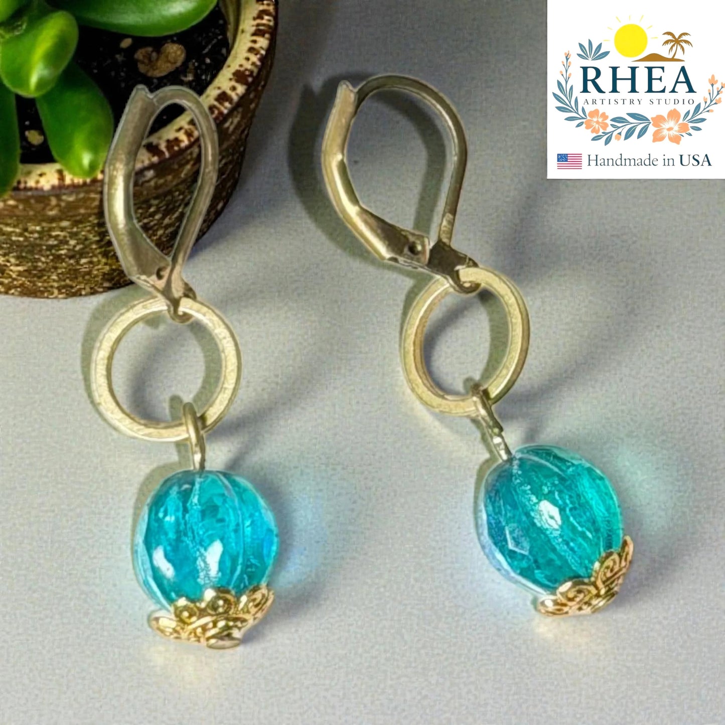 Rhea Artistry Studio aqua blue glass drop earrings with brass accents and leverback closures, approx. 2 inches long.