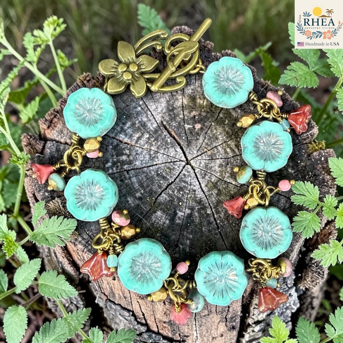 Rhea Artistry Studio handmade bracelet with aqua glass flower beads, coral bead accents, and antique brass toggle clasp.
