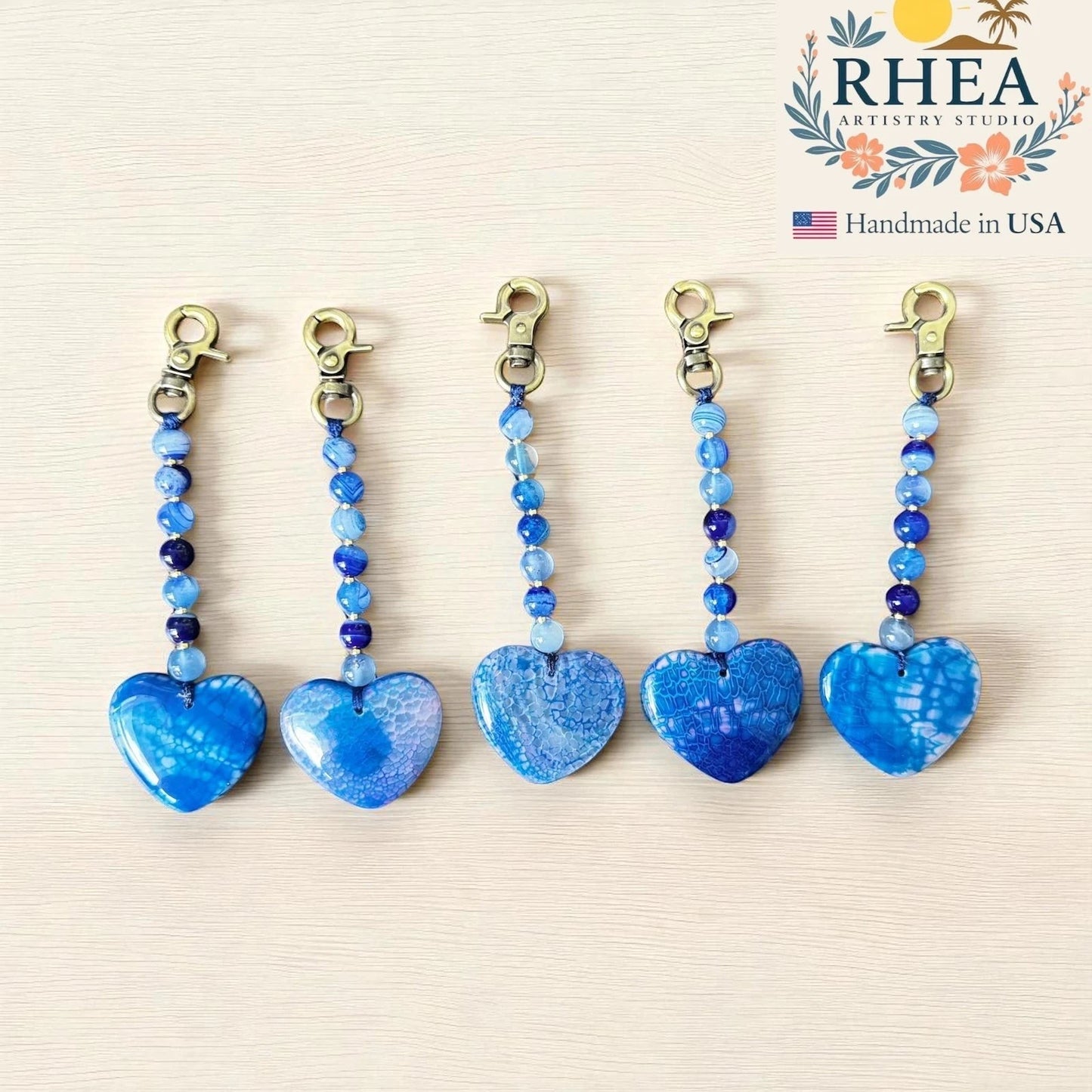 Rhea Artistry Studio blue agate heart bag charm with beaded chain and brushed brass clasp. Handmade gemstone accessory.
