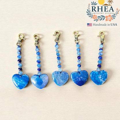 Rhea Artistry Studio blue agate heart bag charm with beaded chain and brushed brass clasp. Handmade gemstone accessory.