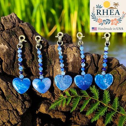 Rhea Artistry Studio blue agate heart bag charms with beaded gemstone accents and brushed brass clasps.