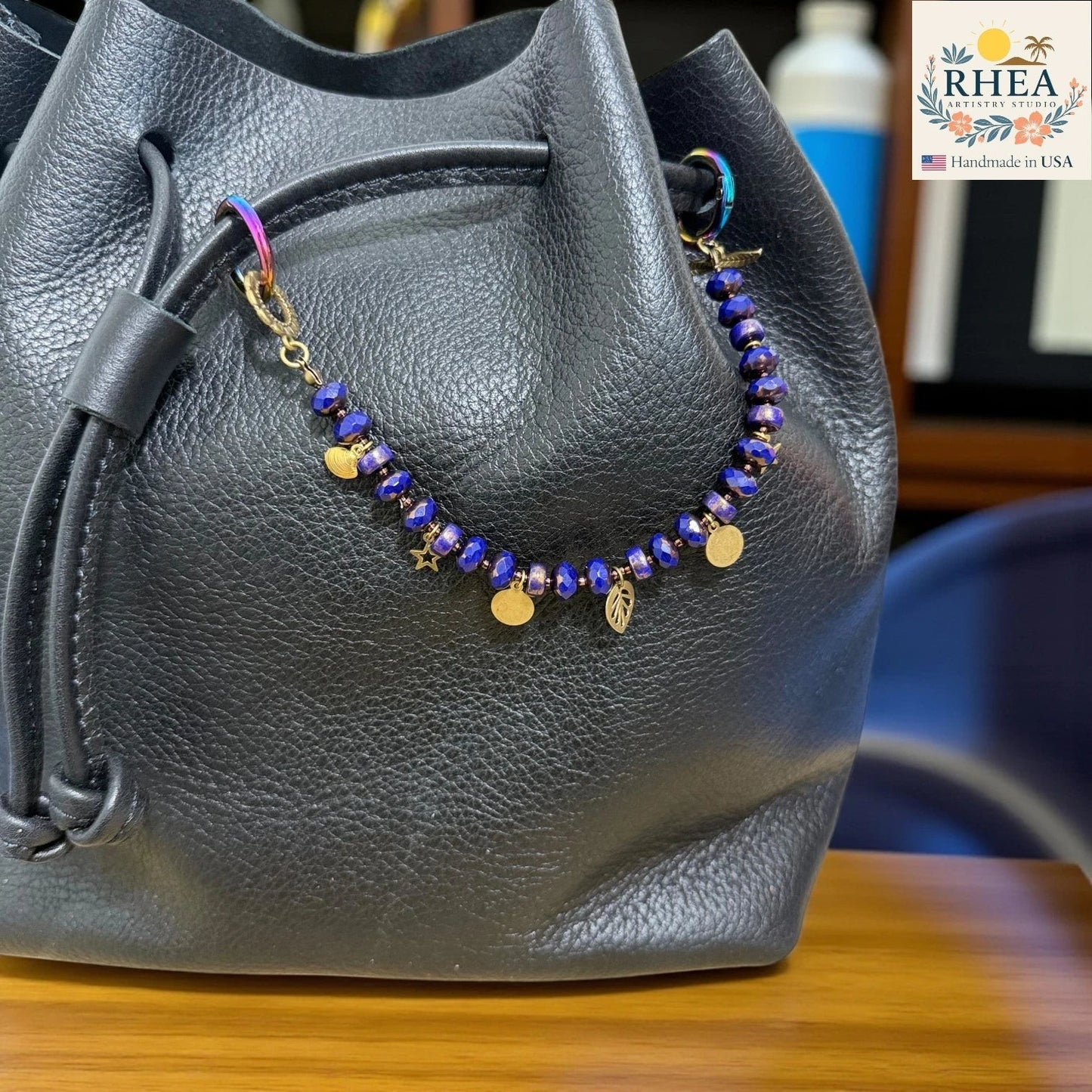 Rhea Artistry Studio handmade beaded purse charm with blue Czech glass beads and brass celestial charms: moon, star, leaf.
