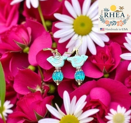 Rhea Artistry Studio light blue bird earrings with blue glass pumpkin beads and brass hardware, approx. 1-1.5 inches long.
