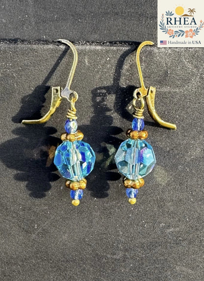 Rhea Artistry Studio blue Czech glass faceted bead earrings with brass hardware and crystal accents, 1.5-2 inches long.
