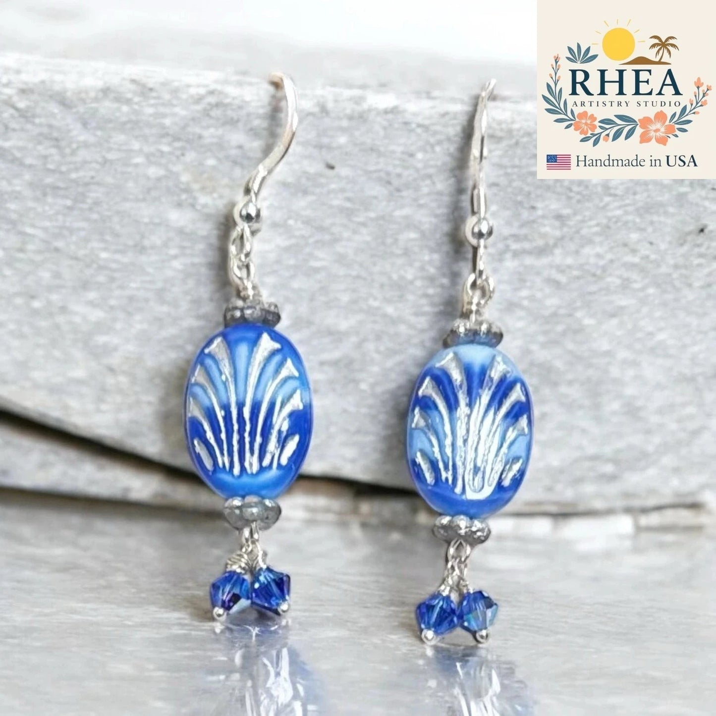 Rhea Artistry Studio coastal blue Czech glass oval beads with silver fan design and Austrian crystals, silver metal hooks.
