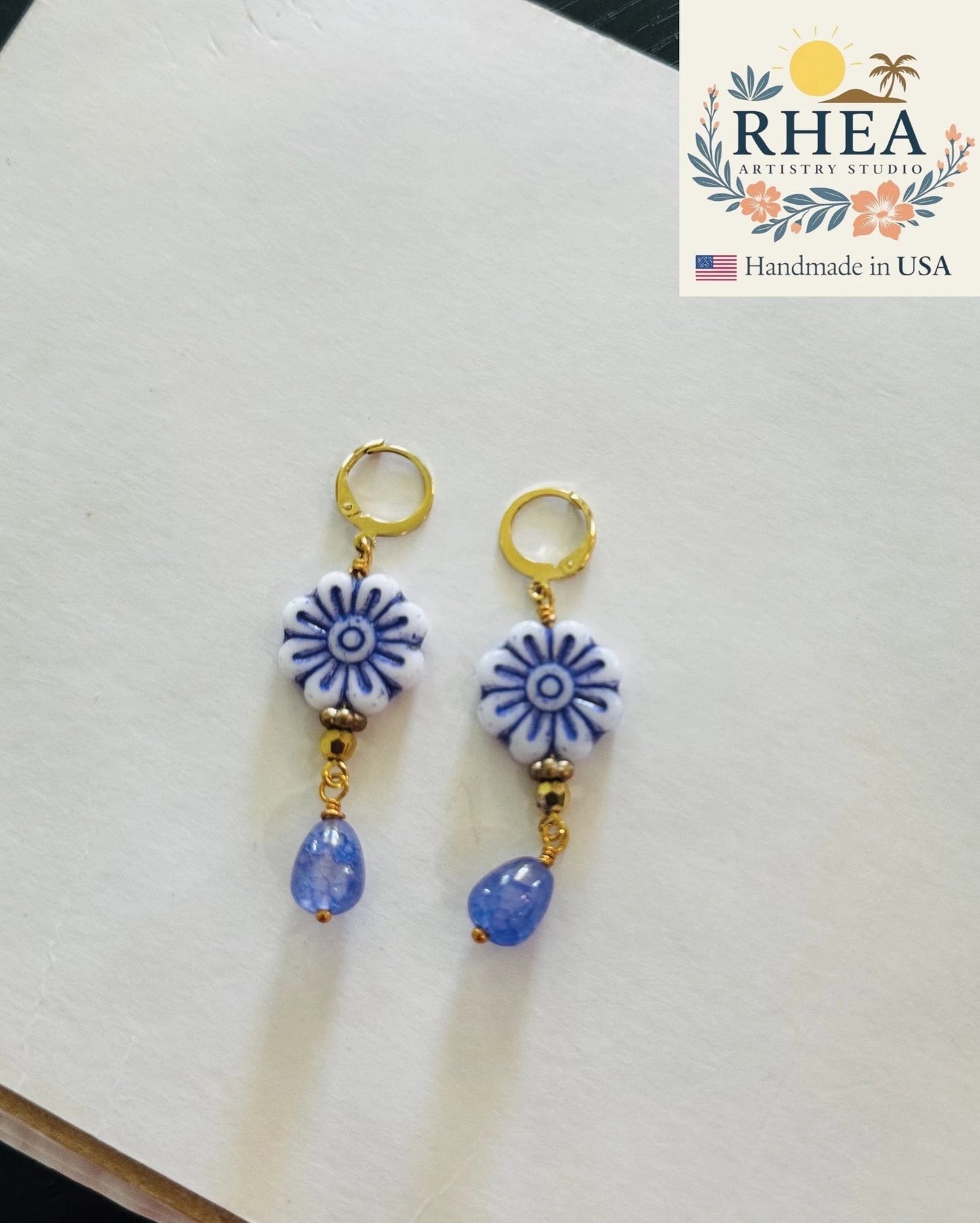 Rhea Artistry Studio blue and white floral Czech glass bead drop earrings with blue gemstone accents and gold plated brass findings.