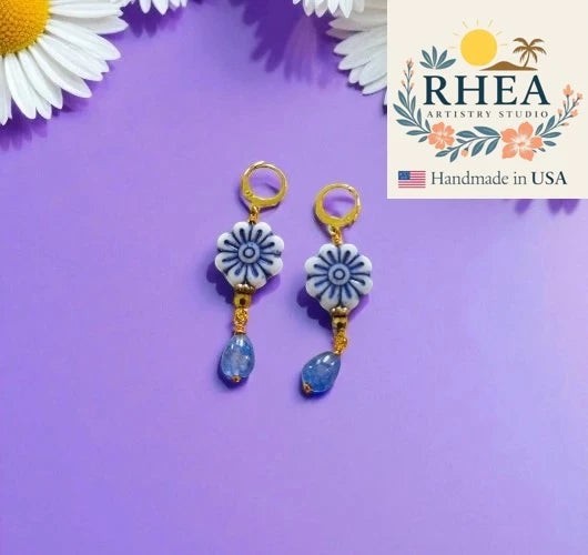 Rhea Artistry Studio blue and white floral drop earrings with blue gemstone accents and gold plated brass findings.