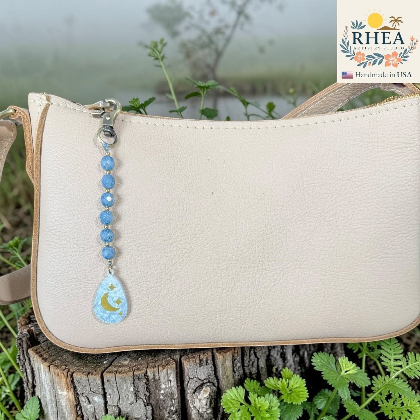Rhea Artistry Studio blue multi-faceted glass bead bag charm with engraved moon and stars pendant