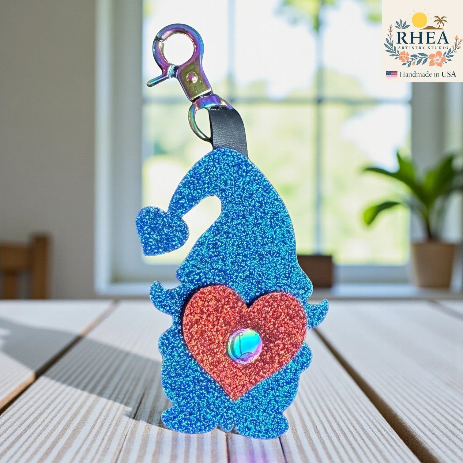 Rhea Artistry Studio blue glitter leather gnome bag charm with red heart detail and rainbow clasp.