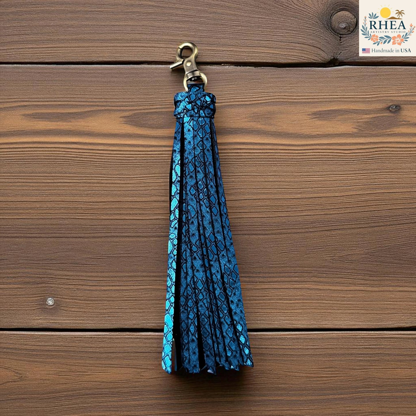 Rhea Artistry Studio handmade blue leather tassel keychain with a textured snakeskin pattern and antique brass lobster clasp.