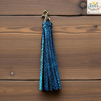 Rhea Artistry Studio handmade blue leather tassel keychain with a textured snakeskin pattern and antique brass lobster clasp.
