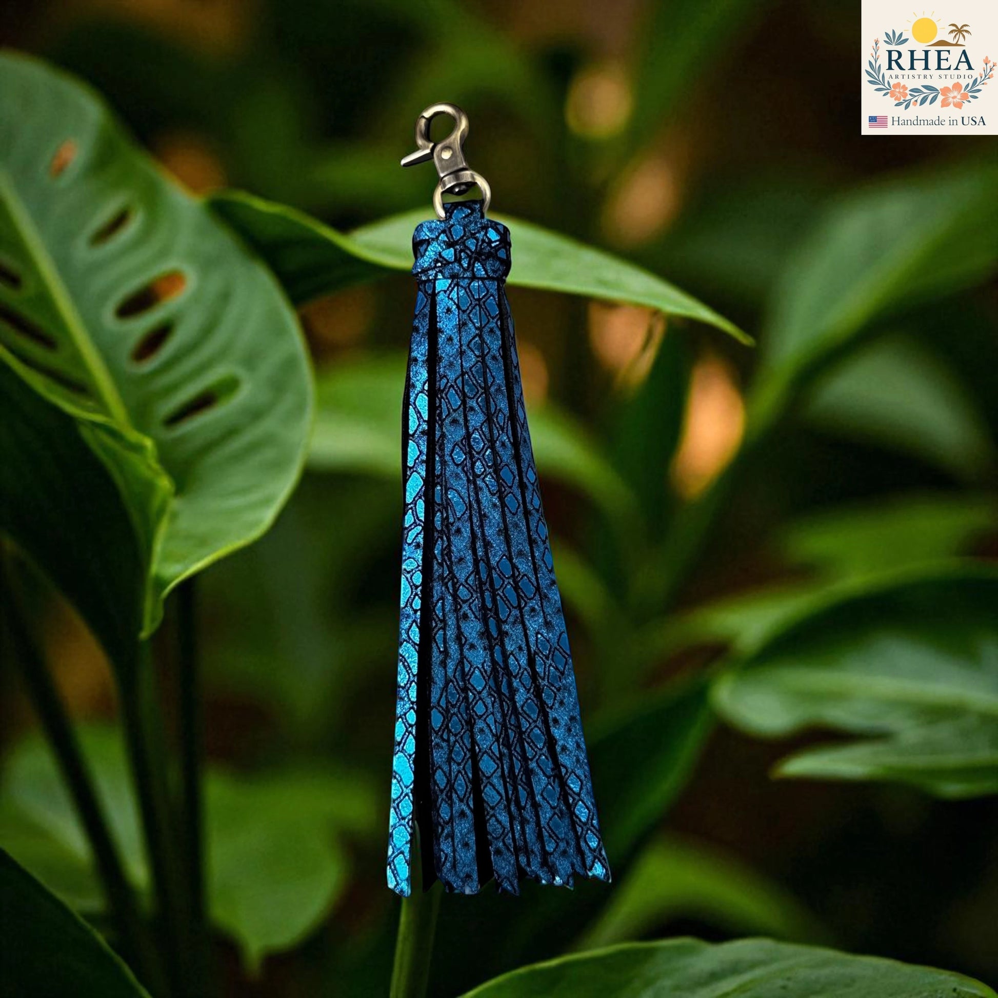 Rhea Artistry Studio handmade blue leather tassel keychain with lobster clasp, featuring a snake-like pattern and glitter finish.