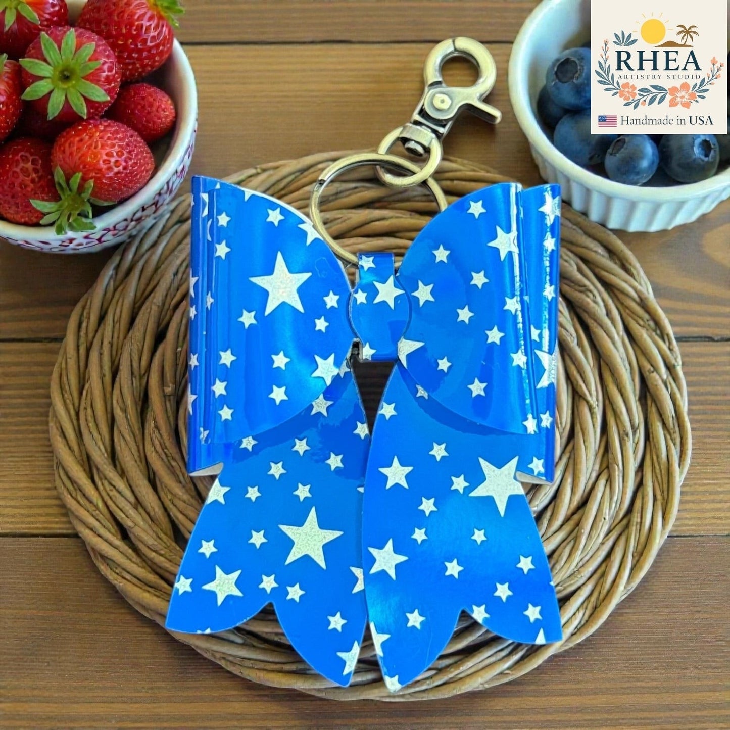 Rhea Artistry Studio blue double-layer French bow bag charm with white stars and brass hardware.