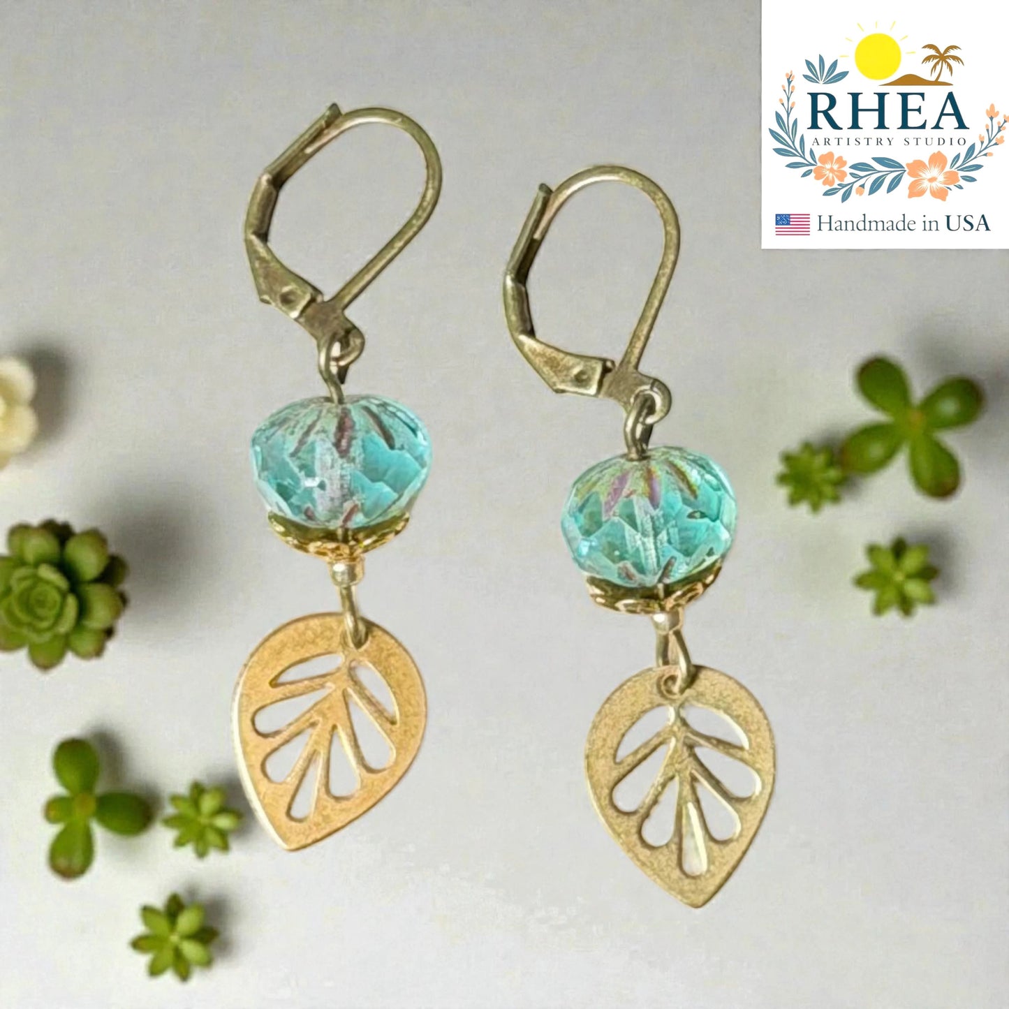 Rhea Artistry Studio handcrafted brass leaf drop earrings with blue faceted glass beads, 2 inches long, leverback closure.