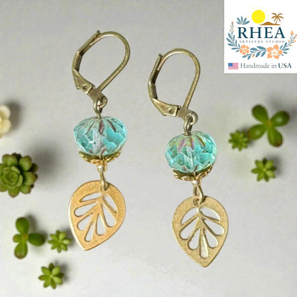 Rhea Artistry Studio handcrafted brass leaf drop earrings with blue faceted glass beads, 2 inches long, leverback closure.