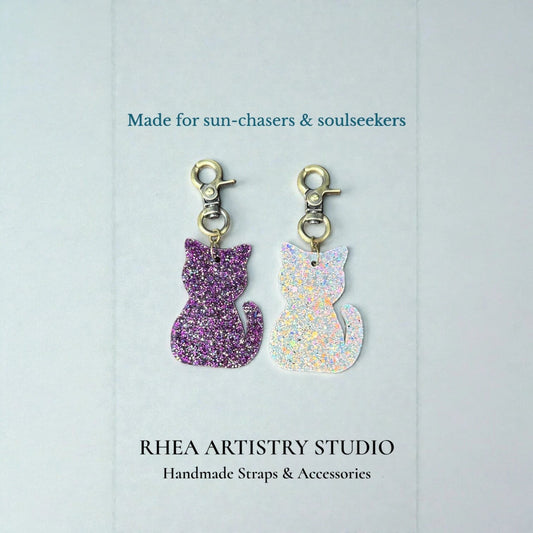 Rhea Artistry Studio purple glitter and holographic cat silhouette acrylic charms with antique brass clasps.