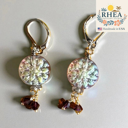 Rhea Artistry Studio Celestial Bloom Earrings: iridescent floral coin beads with plum crystal accents, silver-plated lever-backs, 1.5 inches.