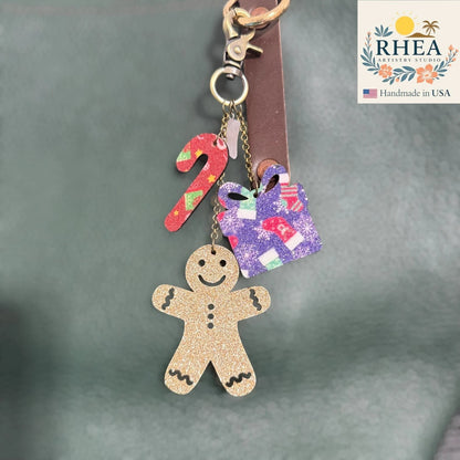 Rhea Artistry Studio handmade Christmas leather charm set with gingerbread man, candy cane, and gift box designs.