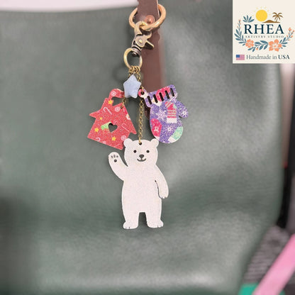 Rhea Artistry Studio handmade leather Christmas charm with polar bear, Christmas tree, and mitten. Antique brass hardware.