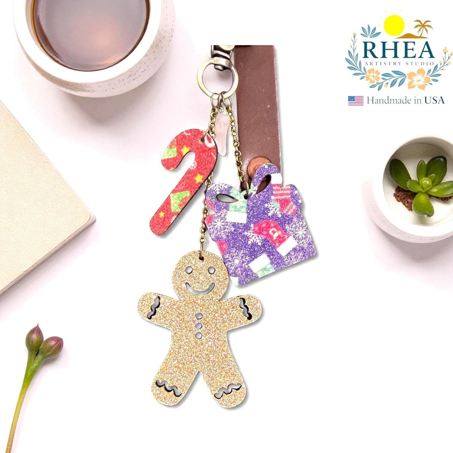 Rhea Artistry Studio Christmas Tales leather charm set with gingerbread man, candy cane, and gift box designs. Glitter and matte finishes with brass hardware.