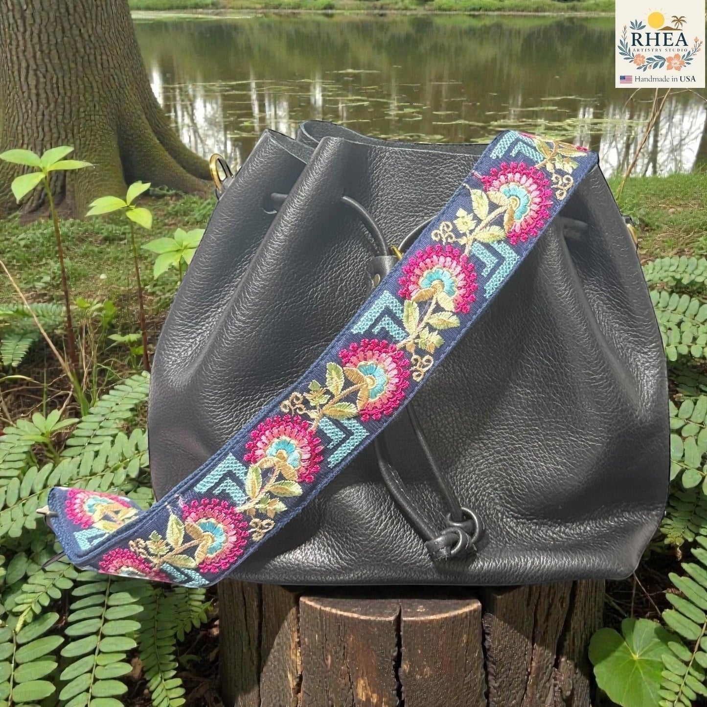 Rhea Artistry Studio navy blue crossbody strap with embroidered crimson floral motifs and blue geometric accents. Adjustable 2-inch width.