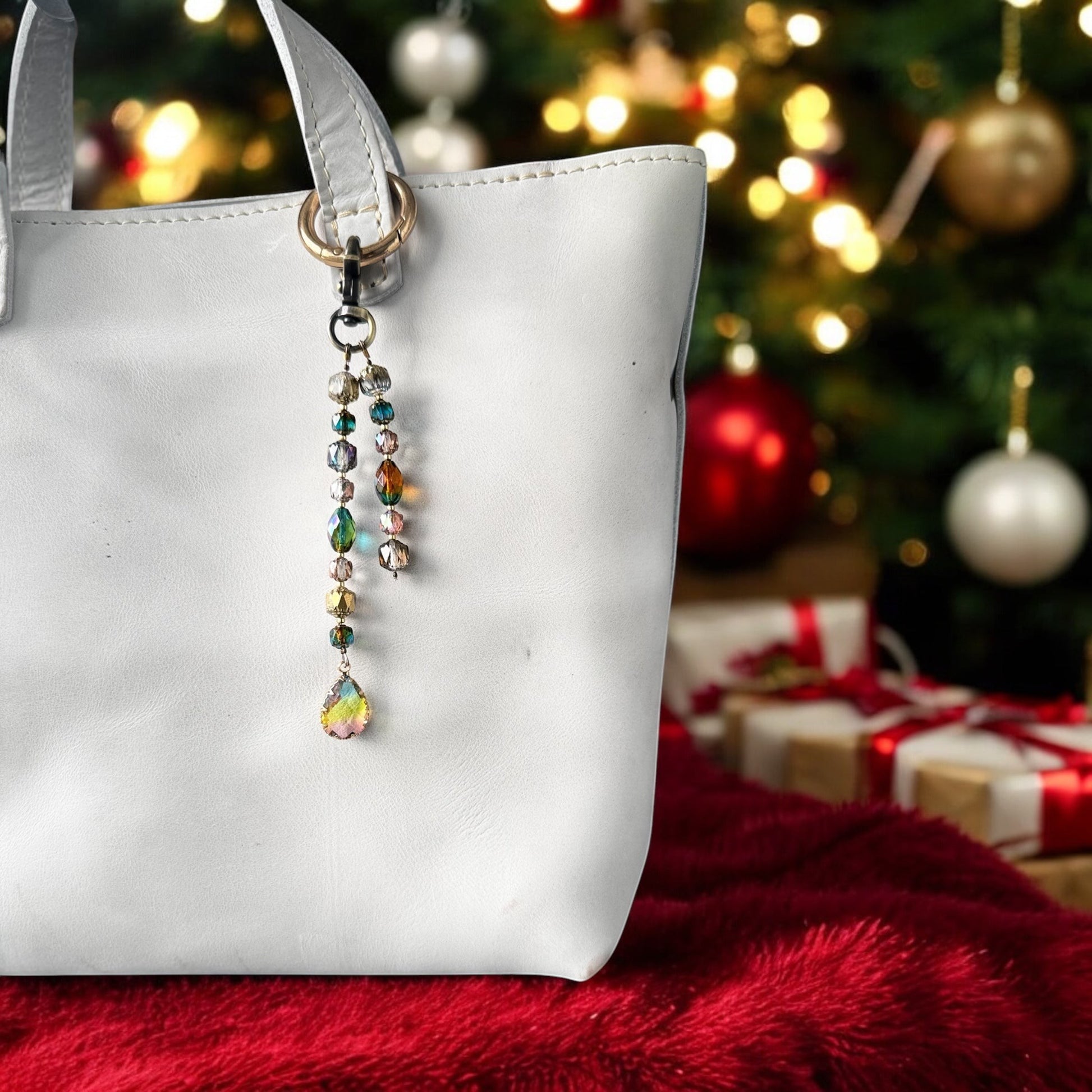Rhea Artistry Studio elegant crystal beaded keychain with teardrop pendant and brass accents on a white tote bag.