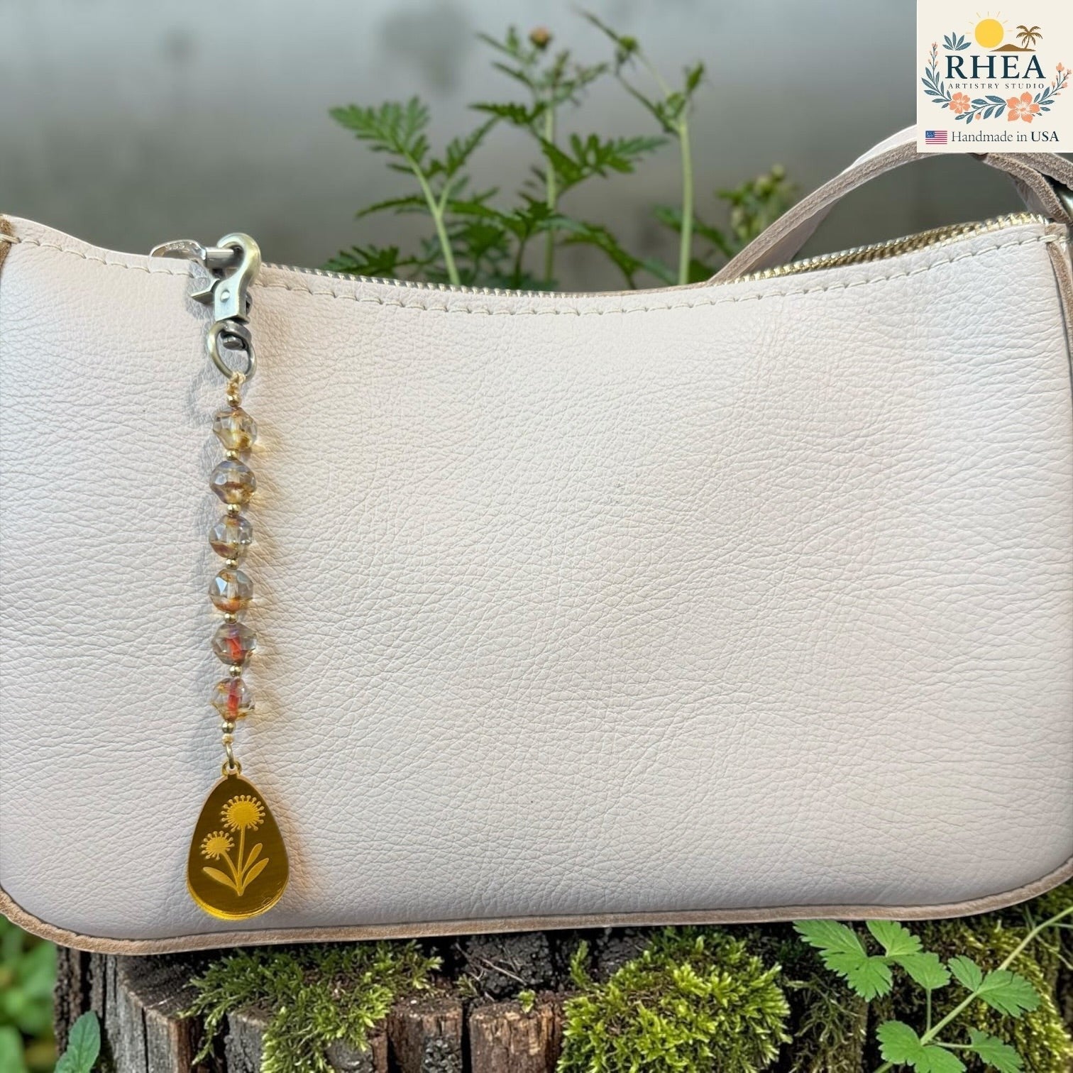 Rhea Artistry Studio artisan bag charm with Czech glass beads, brass accents, and a hand-painted yellow pendant featuring two flowers.