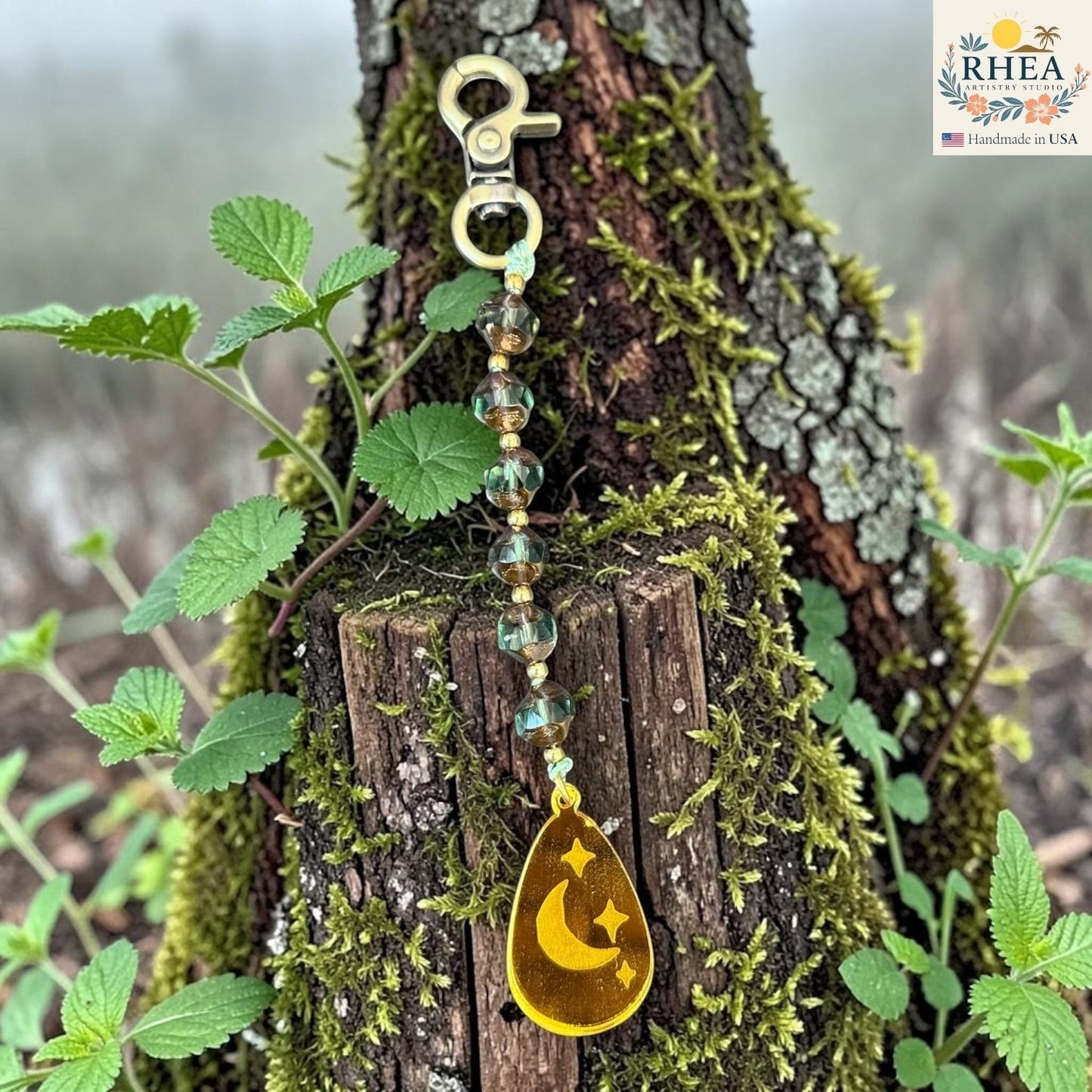 Rhea Artistry Studio artisan bag charm with Czech glass beads, brass accents, and a hand-painted moon and stars pendant.