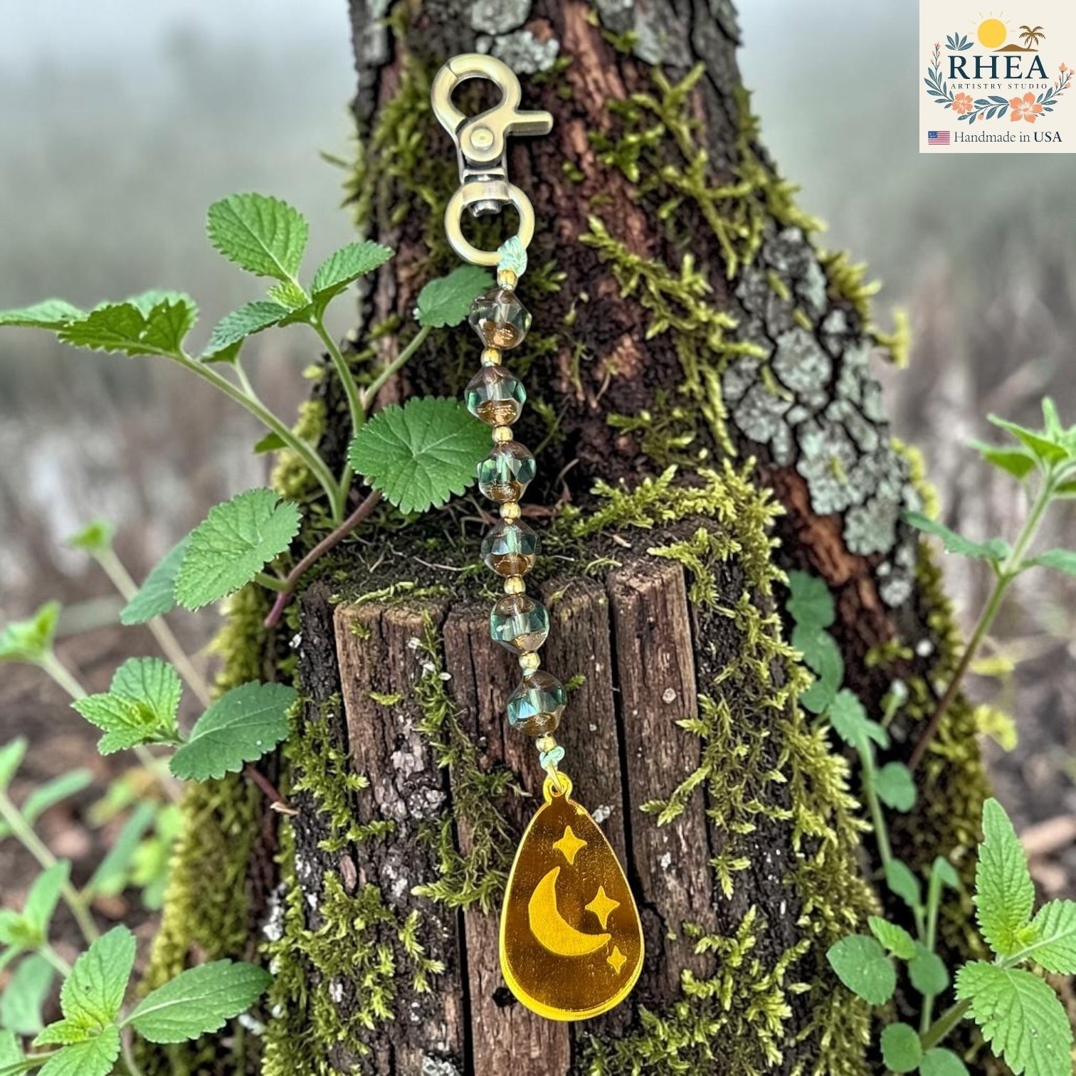 Rhea Artistry Studio artisan bag charm with Czech glass beads, brass accents, and a hand-painted moon and stars pendant.