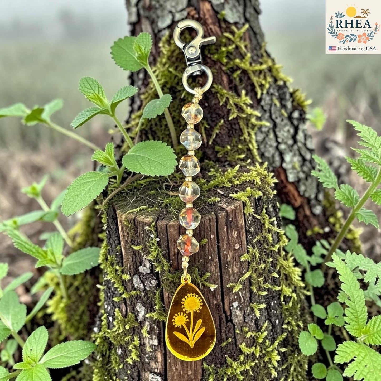 Rhea Artistry Studio artisan bag charm with Czech glass beads, brass accents, and a hand-painted yellow pendant featuring two dandelions.